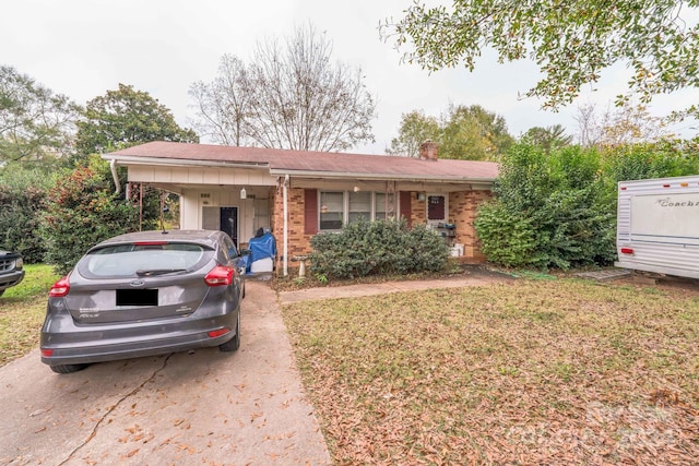 ranch-style home with a carport and a front yard