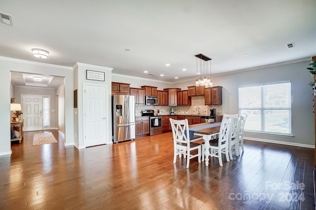 dining room featuring hardwood / wood-style flooring, sink, and ornamental molding