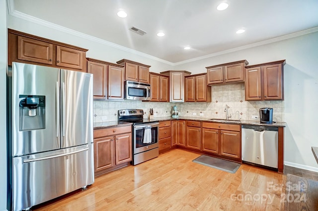 kitchen with stainless steel appliances, crown molding, and sink