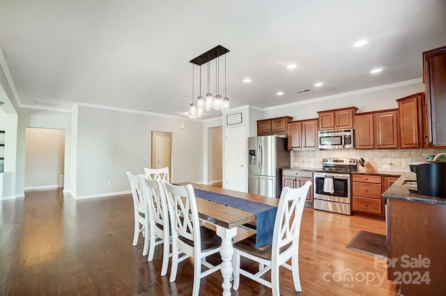 dining area with light hardwood / wood-style floors, ornamental molding, and sink