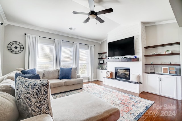 living room with wood-type flooring, vaulted ceiling, ceiling fan, and ornamental molding