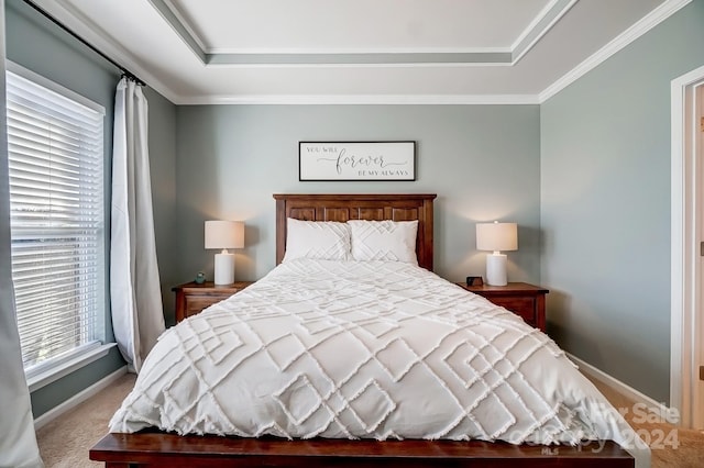 bedroom with ornamental molding, a tray ceiling, and light colored carpet