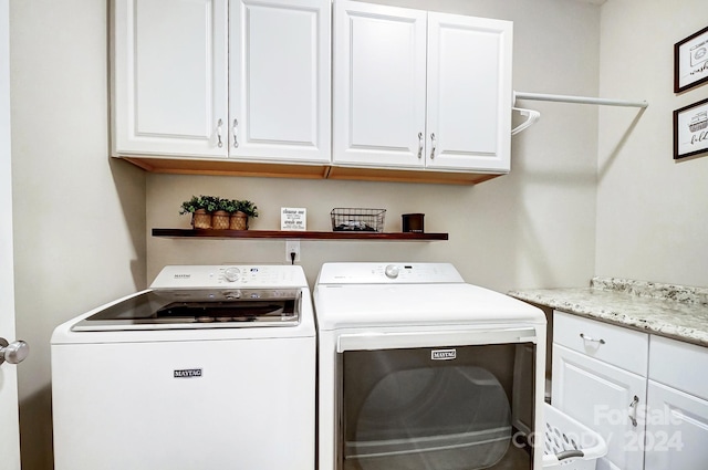 washroom featuring washing machine and clothes dryer and cabinets