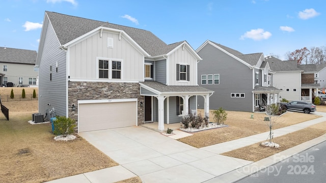 view of front of property with covered porch, a garage, and central air condition unit