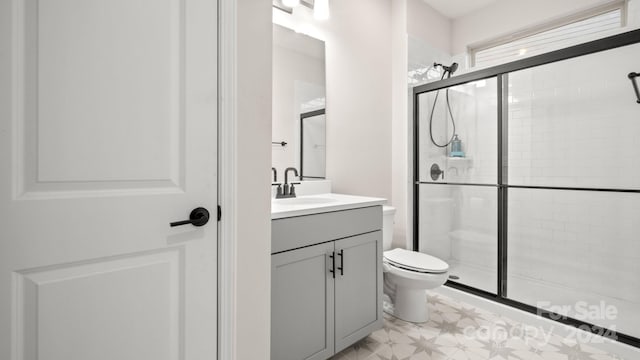 bathroom featuring toilet, vanity, and walk in shower