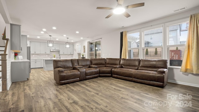 living room with ceiling fan, sink, and light hardwood / wood-style flooring