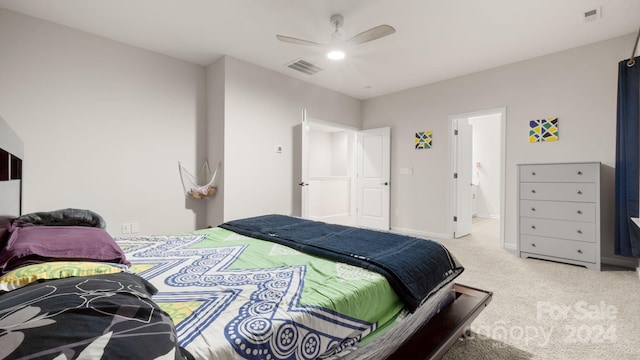 carpeted bedroom with ceiling fan and ensuite bath