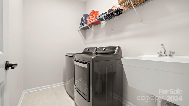 washroom with sink and washing machine and clothes dryer