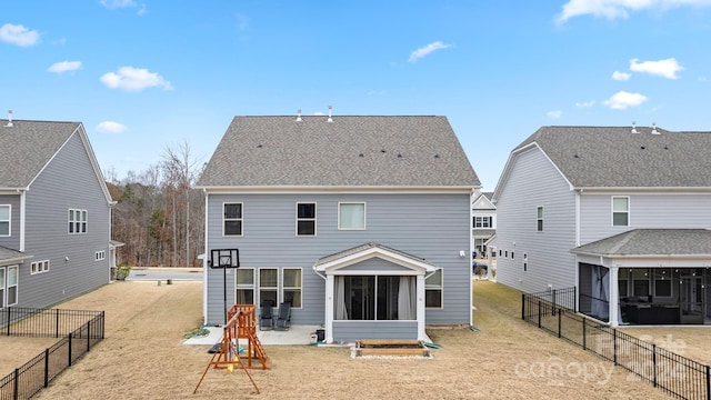 rear view of property featuring a yard and a sunroom