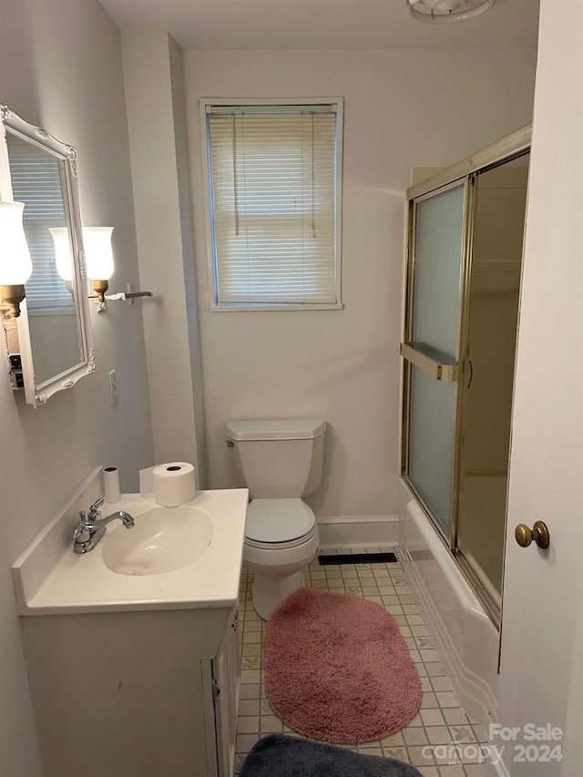 full bathroom with shower / bath combination with glass door, tile patterned flooring, vanity, and toilet