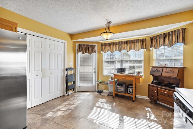 entryway with tile patterned floors, a textured ceiling, and baseboards