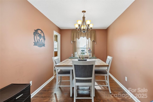 dining room with a chandelier, dark wood-style floors, and baseboards
