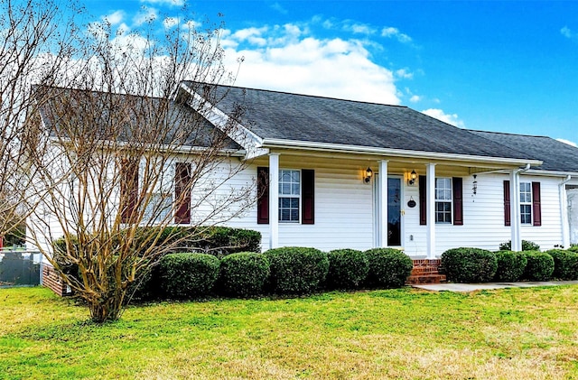 view of front of house with a front yard, a shingled roof, and covered porch