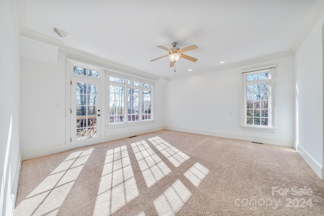 empty room with ceiling fan, light colored carpet, and ornamental molding