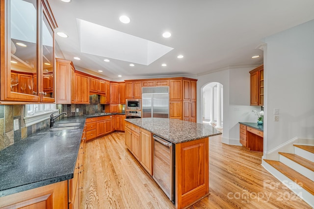 kitchen featuring built in appliances, a center island, light hardwood / wood-style floors, and wine cooler