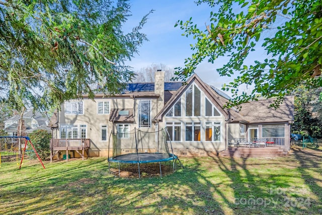 back of property featuring a playground, a yard, a trampoline, and a patio