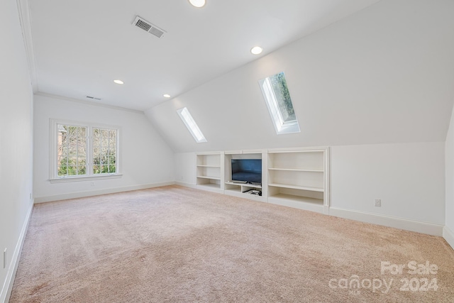 additional living space with light carpet and lofted ceiling with skylight