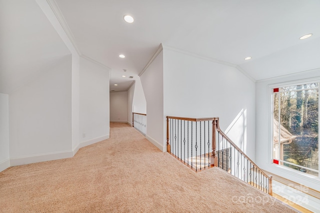 hallway featuring light carpet, vaulted ceiling, and crown molding