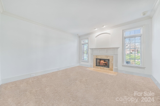 unfurnished living room featuring a fireplace, plenty of natural light, and carpet floors