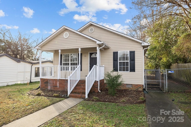 bungalow-style home with covered porch and a front lawn