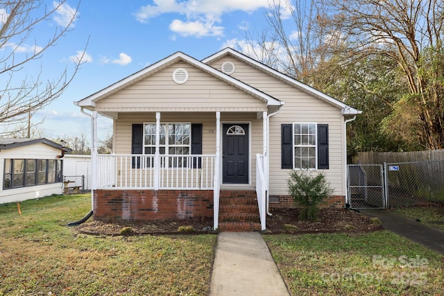 bungalow with covered porch and a front lawn