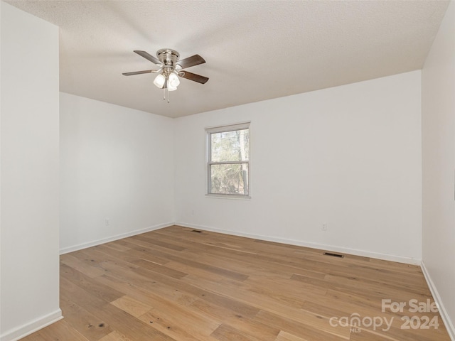 unfurnished room featuring ceiling fan, light hardwood / wood-style flooring, and a textured ceiling