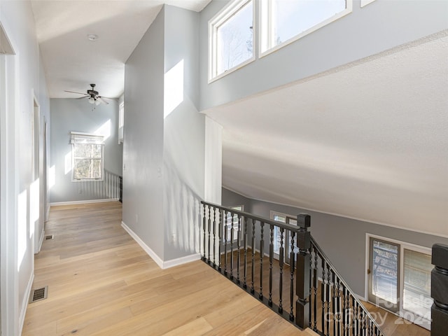 stairway featuring ceiling fan, hardwood / wood-style floors, and lofted ceiling