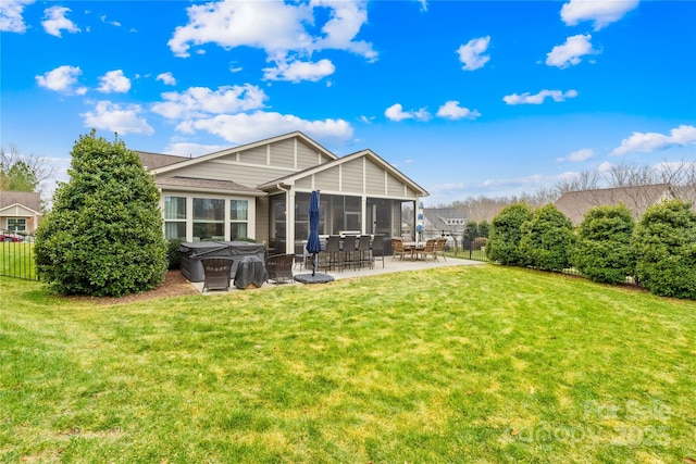 back of property with a yard, a patio area, and a sunroom