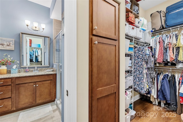 bathroom with walk in shower, vanity, and hardwood / wood-style floors