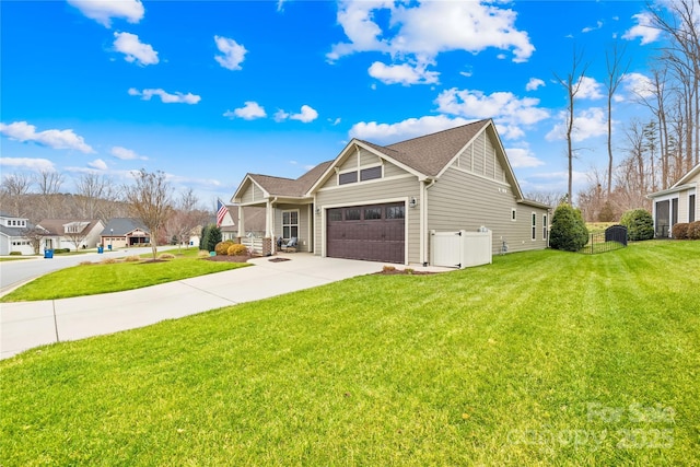 view of front of property featuring driveway, an attached garage, and a front lawn