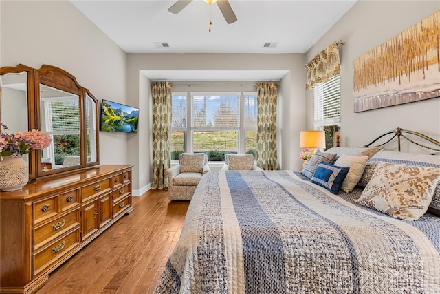 bedroom with multiple windows, ceiling fan, and light wood-type flooring