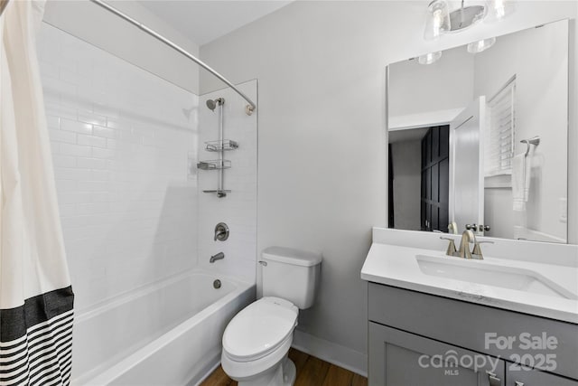 full bath featuring shower / bath combo, baseboards, toilet, wood finished floors, and vanity