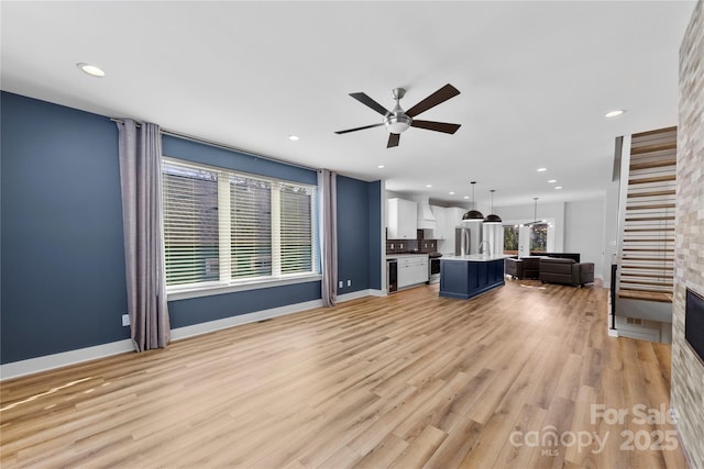 unfurnished living room with light wood-style floors, ceiling fan, baseboards, and recessed lighting