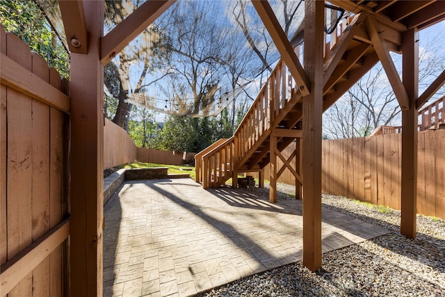 view of patio featuring a fenced backyard and stairway