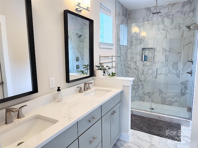 bathroom with a stall shower, marble finish floor, a sink, and double vanity