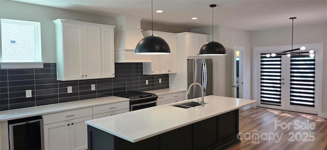 327 Coxe Ave, Charlotte, NC 28208 - kitchen with stainless steel appliances, wine cooler, a sink, an island with sink, and white cabinetry