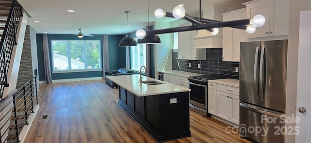 327 Coxe Ave, Charlotte, NC 28208 - kitchen featuring appliances with stainless steel finishes, a center island with sink, light countertops, wood finished floors, and open floor plan