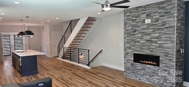 327 Coxe Ave, Charlotte, NC 28208 - unfurnished living room with a sink, ceiling fan, light wood-style floors, recessed lighting, and baseboards