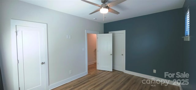 327 Coxe Ave, Charlotte, NC 28208 - unfurnished bedroom featuring wood finished floors, baseboards, a ceiling fan, and a closet