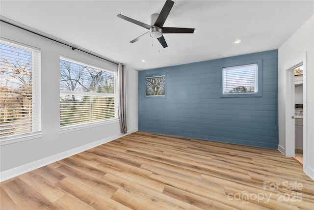 327 Coxe Ave, Charlotte, NC 28208 - empty room with healthy amount of natural light, ceiling fan, light wood finished floors, wooden walls, and baseboards
