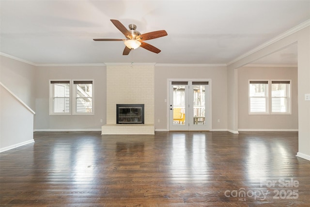 unfurnished living room featuring dark hardwood / wood-style flooring, ceiling fan, crown molding, and a brick fireplace