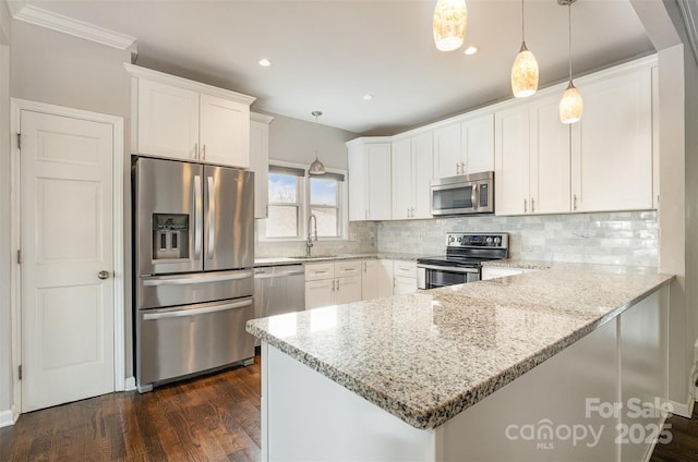 kitchen with white cabinets, light stone counters, hanging light fixtures, and appliances with stainless steel finishes