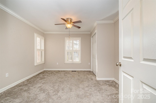 empty room with light colored carpet, ceiling fan, and crown molding