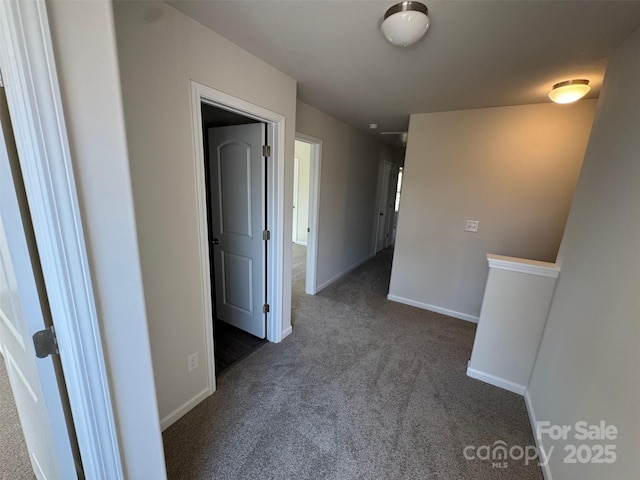 hall with dark colored carpet