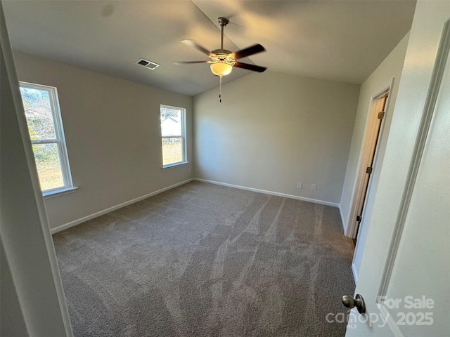 spare room with dark colored carpet, lofted ceiling, and ceiling fan