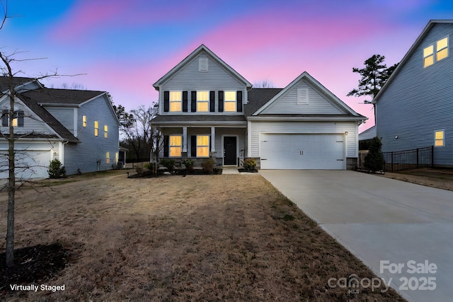 traditional-style house with a garage, concrete driveway, fence, and a front lawn