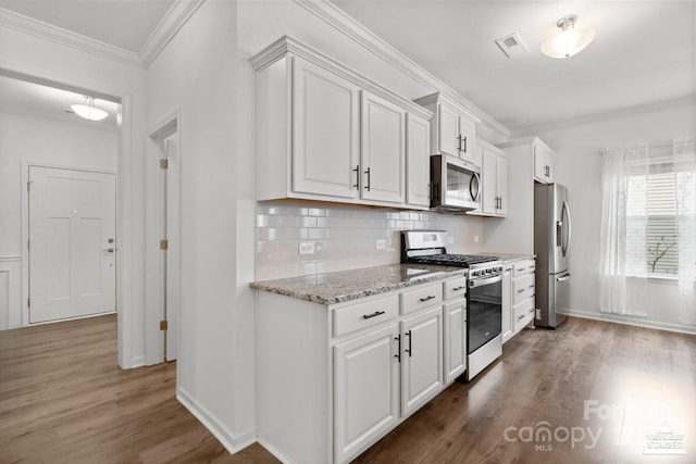 kitchen with white cabinetry, stainless steel appliances, crown molding, and wood finished floors