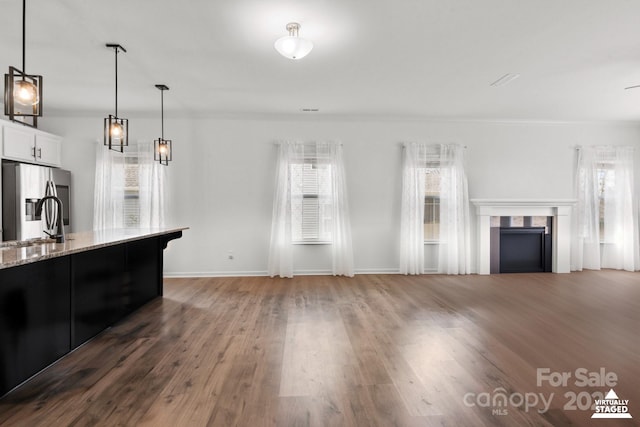 living area featuring ornamental molding, a fireplace, baseboards, and wood finished floors