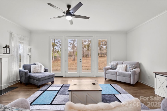 living area featuring a ceiling fan, a fireplace, crown molding, and wood finished floors