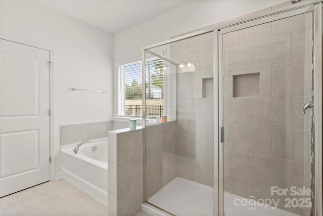 bathroom featuring a shower stall and a bath